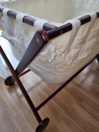 minicuna de madera con ruedas y ropa