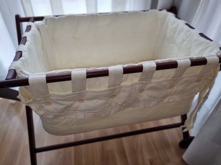 minicuna de madera con ruedas y ropa
