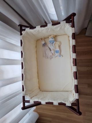 minicuna de madera con ruedas y ropa