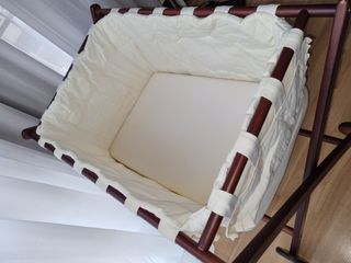 minicuna de madera con ruedas y ropa