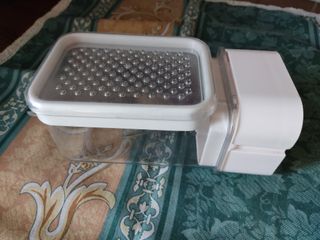 Grattugia con vaschetta e meccanismo manuale