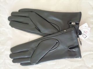 Guantes nuevos negros táctiles. mujer con etiqu