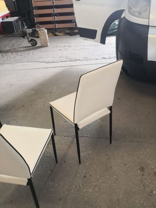 Mesa de cristal con cuatro sillas.