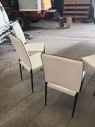 Mesa de cristal con cuatro sillas.