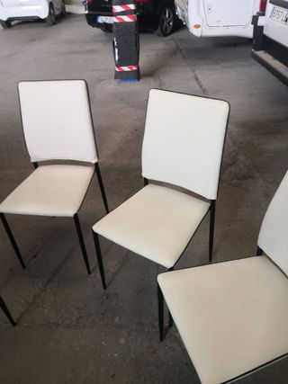 Mesa de cristal con cuatro sillas.