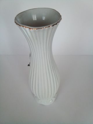 Jarrón blanco con flores y aves en la superficie