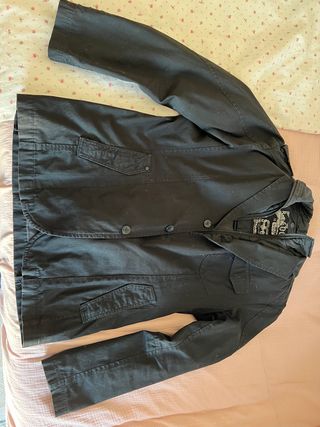 Chaqueta negra de pana lisa con forro interior.