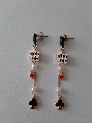 Pendientes de cadena dorada y naipes