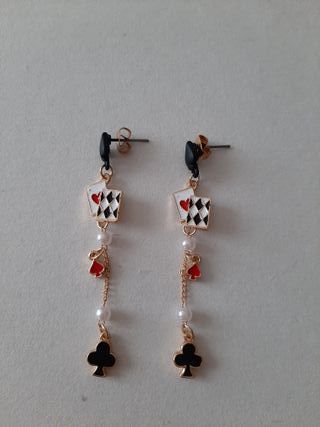 Pendientes de cadena dorada y naipes