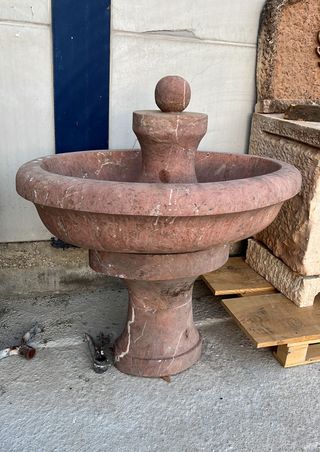 Fuente central de mármol rojo ovalada.