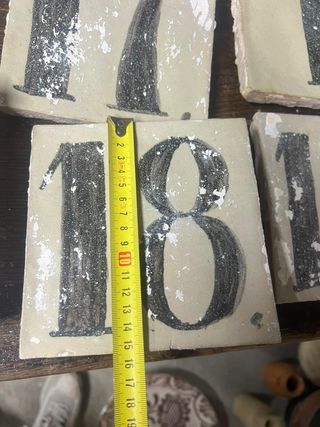 Antiguos números en baldosa de barro