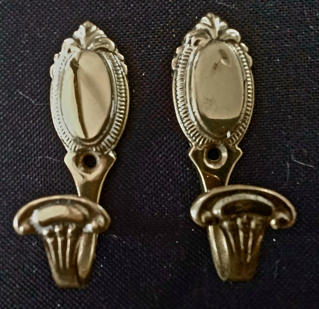 Pequeñas perchas de metal dorado para clavar.