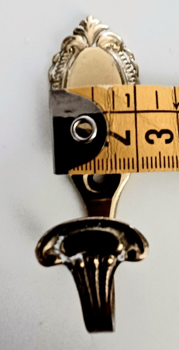 Pequeñas perchas de metal dorado para clavar.