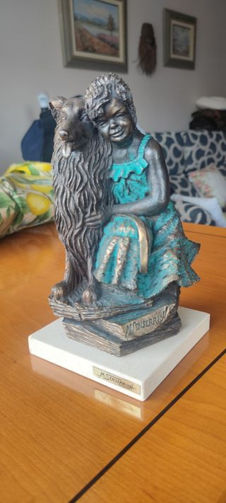 Escultura de niña con perro