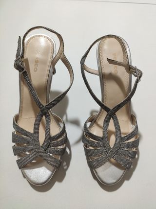 Sandalias de tacon estrecho plateadas.