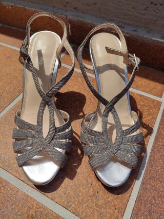 Sandalias de tacon estrecho plateadas.