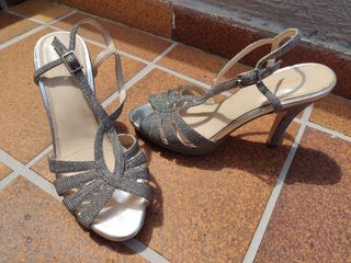 Sandalias de tacon estrecho plateadas.