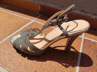 Sandalias de tacon estrecho plateadas.