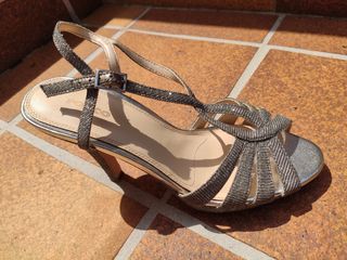 Sandalias de tacon estrecho plateadas.