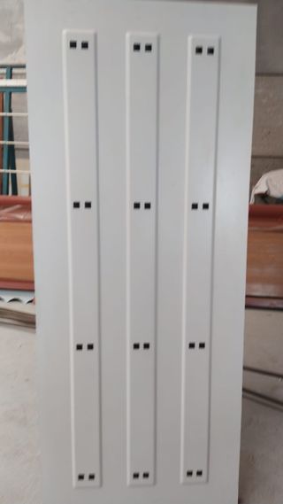 Puerta de entrada blanca con clavos forjados