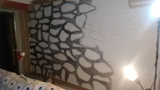 Pintor Aerografista pinta ladrillos en paredes