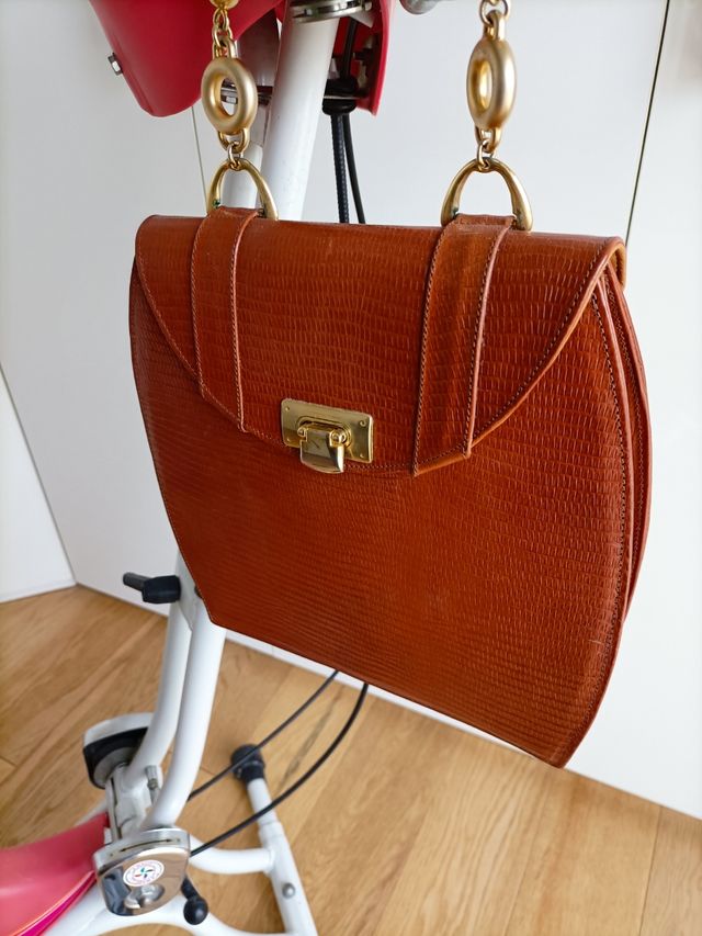 borsa in pelle con manici in metallo dorato.