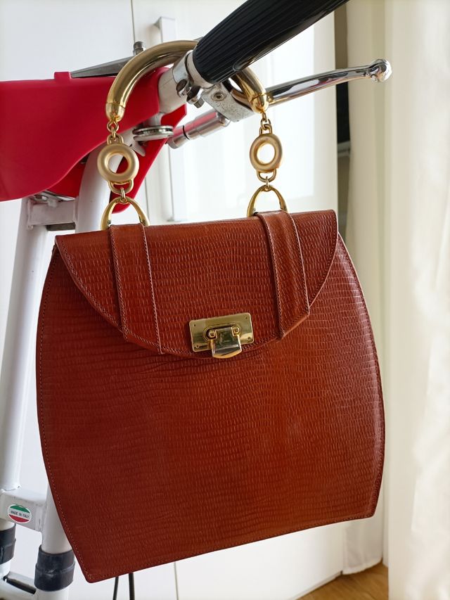 borsa in pelle con manici in metallo dorato.