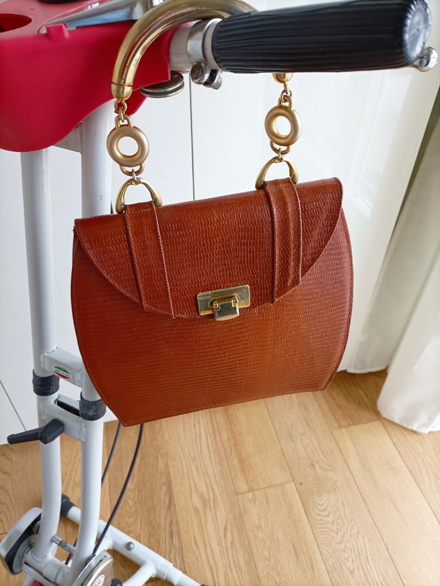 borsa in pelle con manici in metallo dorato.