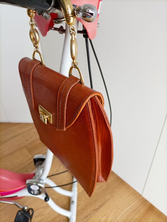 borsa in pelle con manici in metallo dorato.