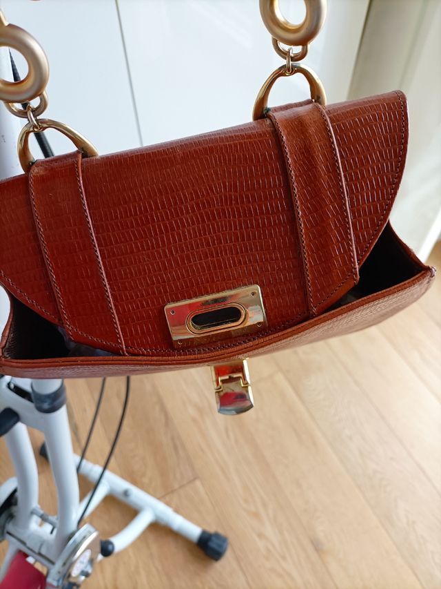 borsa in pelle con manici in metallo dorato.