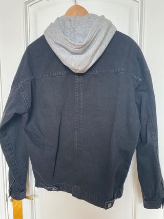 Cazadora vaquera negra con capucha extraible.