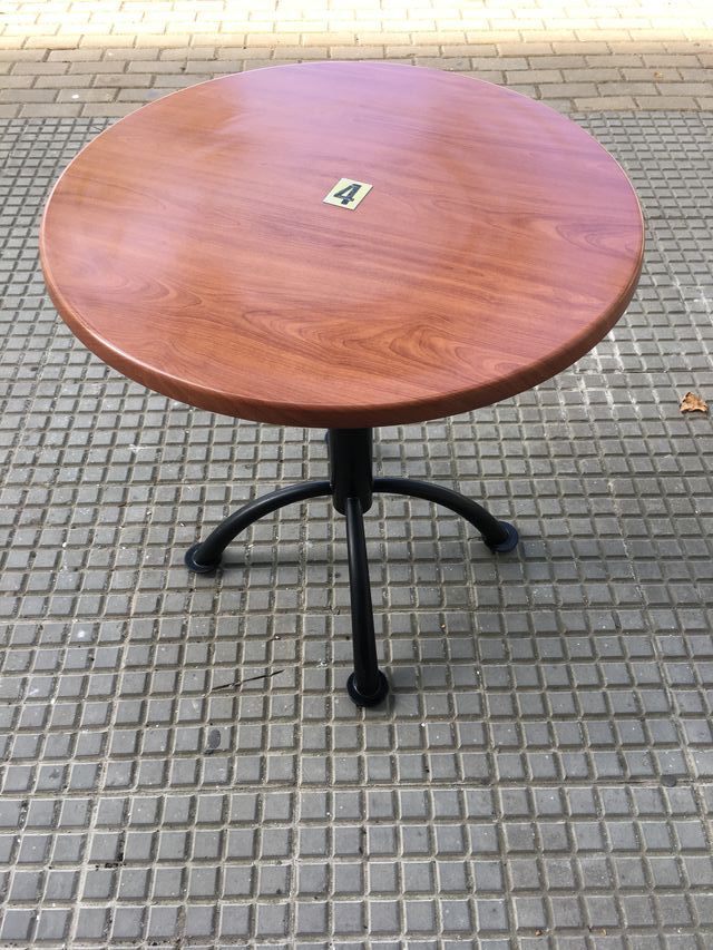 Mesas redondas marrones con pata central...