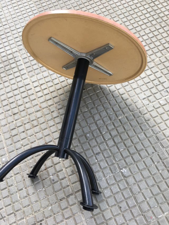 Mesas redondas marrones con pata central...