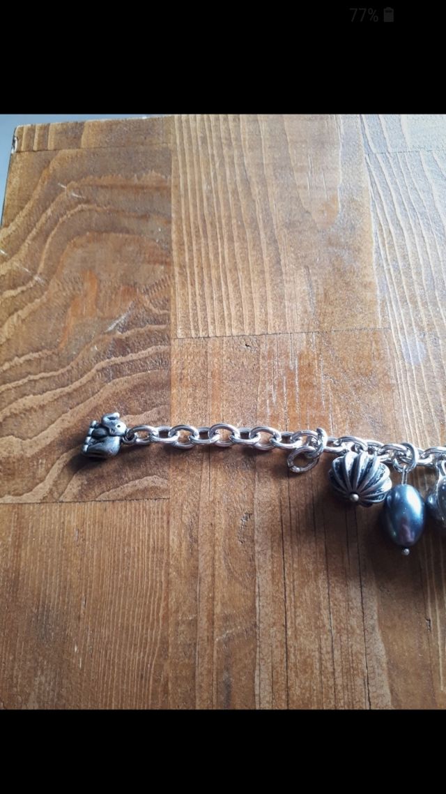 Bracciale color argento con ciondoli. Nuovo