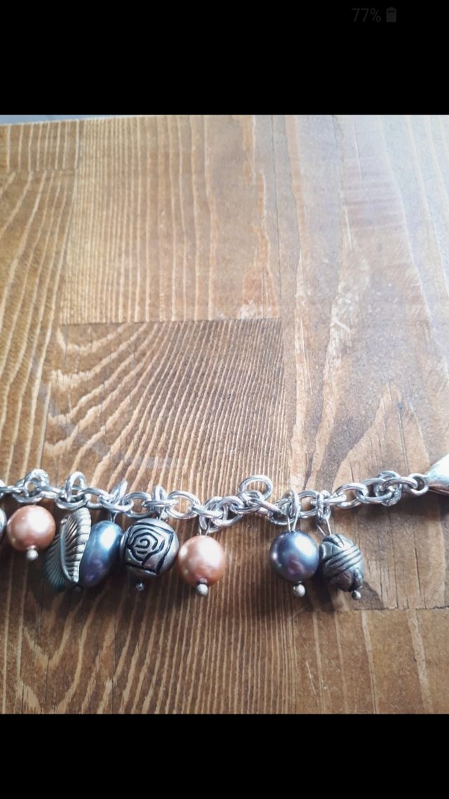 Bracciale color argento con ciondoli. Nuovo