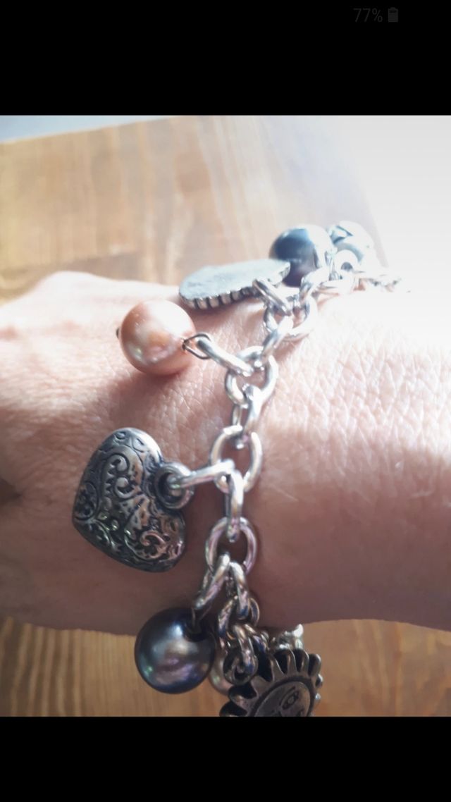 Bracciale color argento con ciondoli. Nuovo