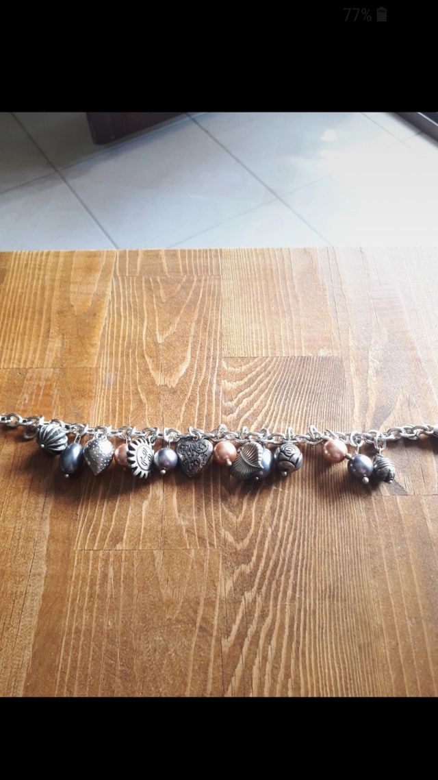 Bracciale color argento con ciondoli. Nuovo