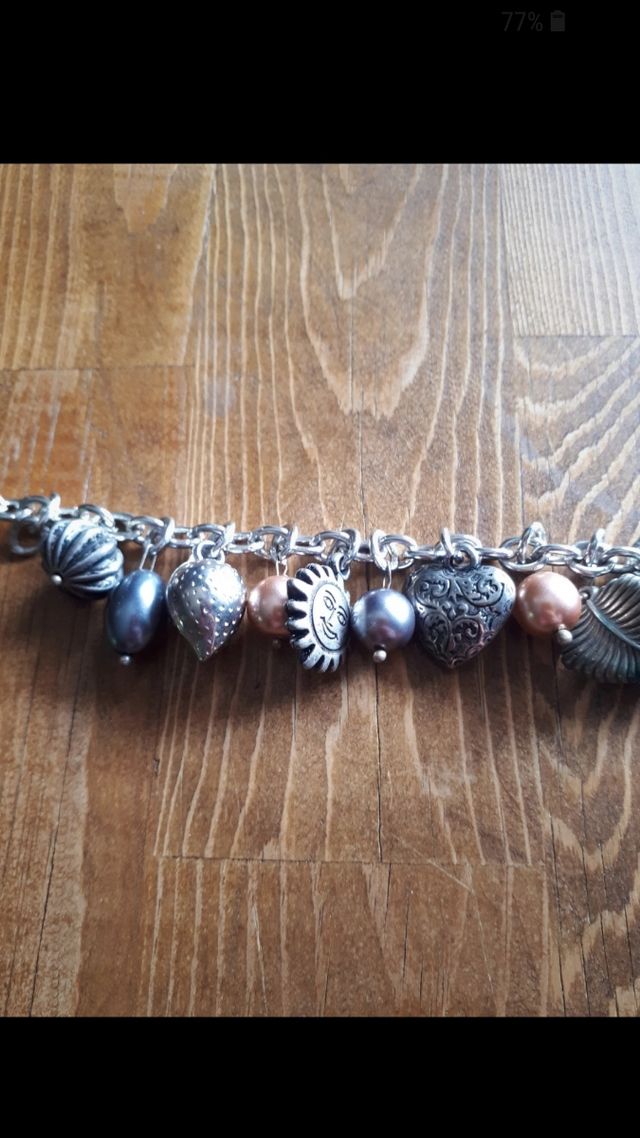 Bracciale color argento con ciondoli. Nuovo