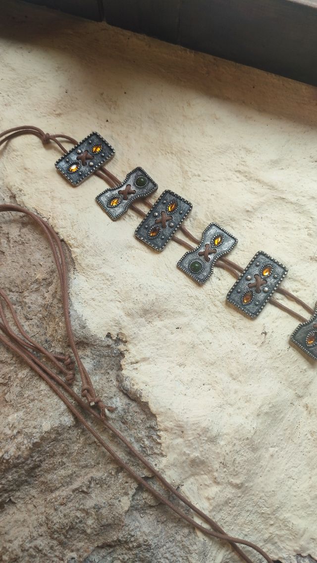 Cinturón de piezas de metal con piedras de colores