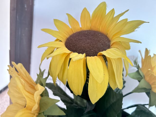 Girassóis artificiais e vaso de latão