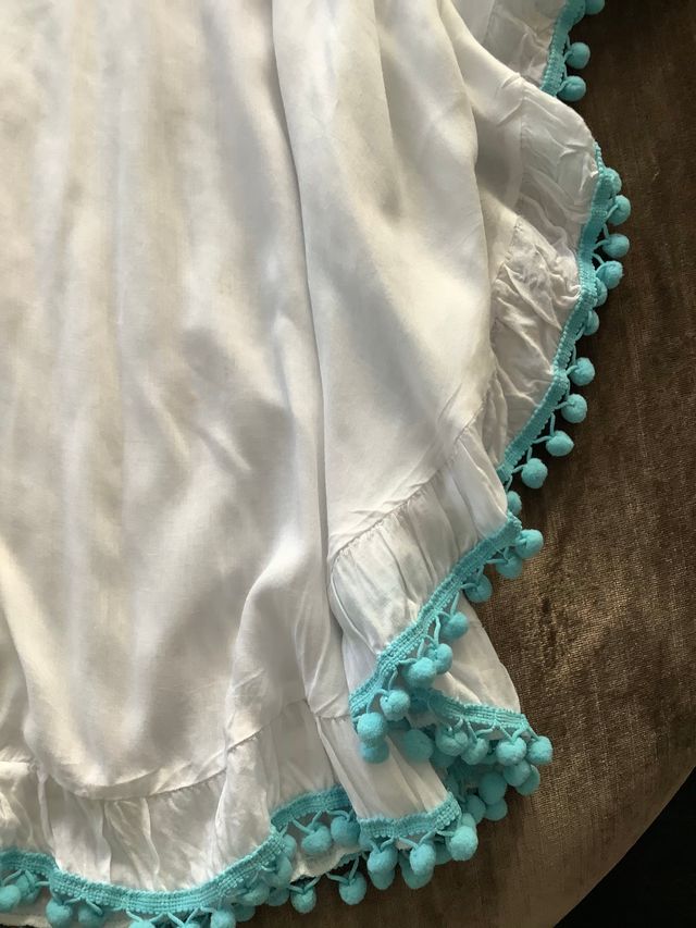 Camisola blanca con borlas turquesas