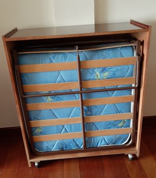 Cama plegable en mueble. Con colchón.