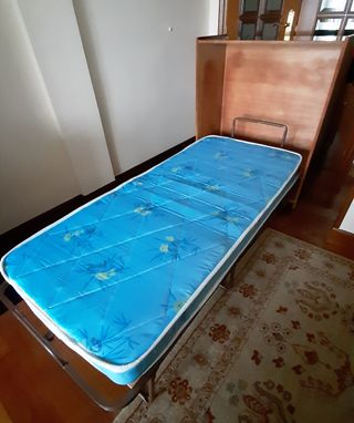 Cama plegable en mueble. Con colchón.