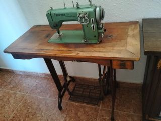 Dos máquinas de coser antiguas con su mueble