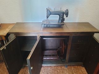 Dos máquinas de coser antiguas con su mueble