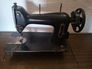 Dos máquinas de coser antiguas con su mueble