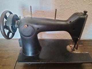 Dos máquinas de coser antiguas con su mueble