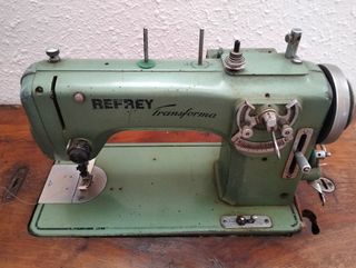 Dos máquinas de coser antiguas con su mueble