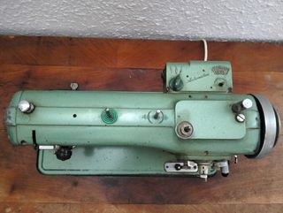 Dos máquinas de coser antiguas con su mueble