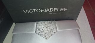 Cartera color plata con cadena.